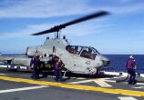Image: Flight deck crew members aboard 
      the USS Wasp hot refuel an AH-1W Super Cobra.