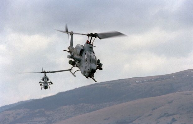 Image: Two U.S. Marine AH-1W Super Cobra helicopters fly over the live fire range at Glamoc.