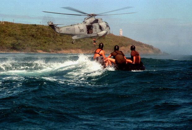 Image: Explosive Ordnance Disposal technician jumps from a SH-3H Sea King helicopter.