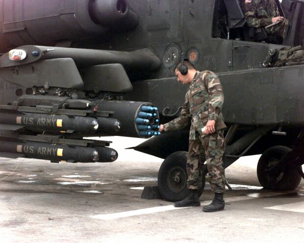 Image: An ammunition supply non-commissioned officer checks the rockets on an AH-64 Apache.
