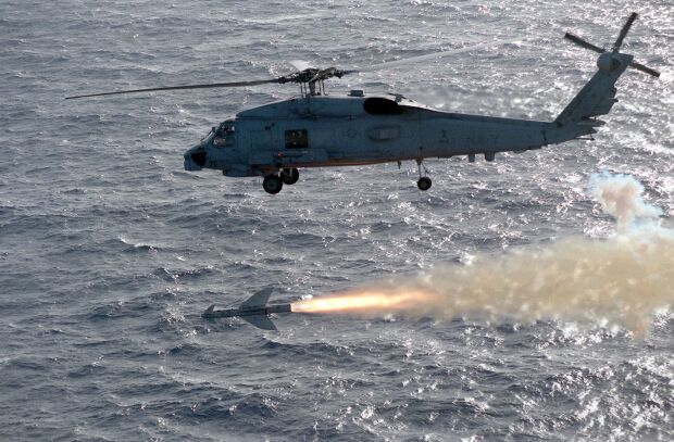 Image: An SH-60B Seahawk helicopter fires a Penguin missile at a target.