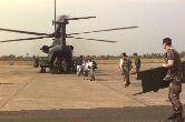 Image: A U.S. Air Force Para-rescueman waits as evacuees come off a MH-53 Pavelow.