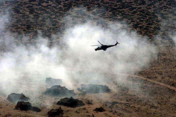 Image: MI-24 Hind attack helicopter simulates ground attacks on an air defense site.
